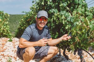 Founder Branko showing local Grk grapes in a vineyard during the Lumbarda buggy wine tasting tour in Korcula